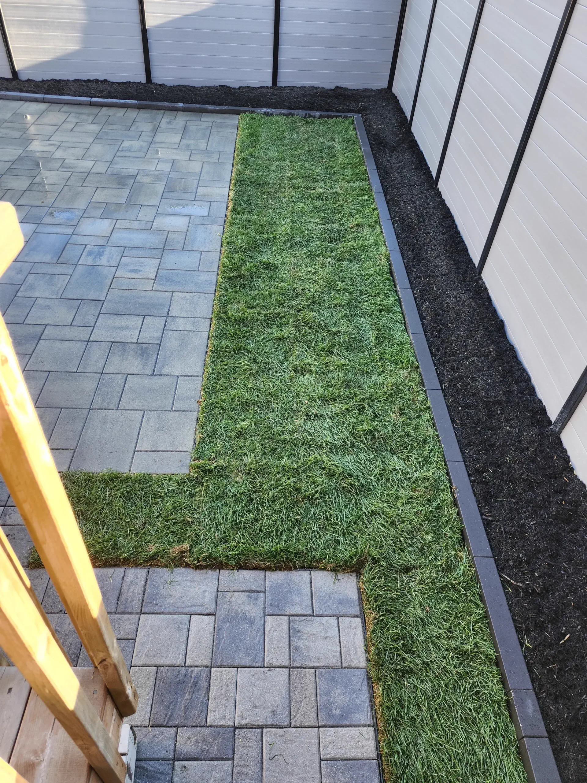 Grey backyard patio with side-yard transitions
