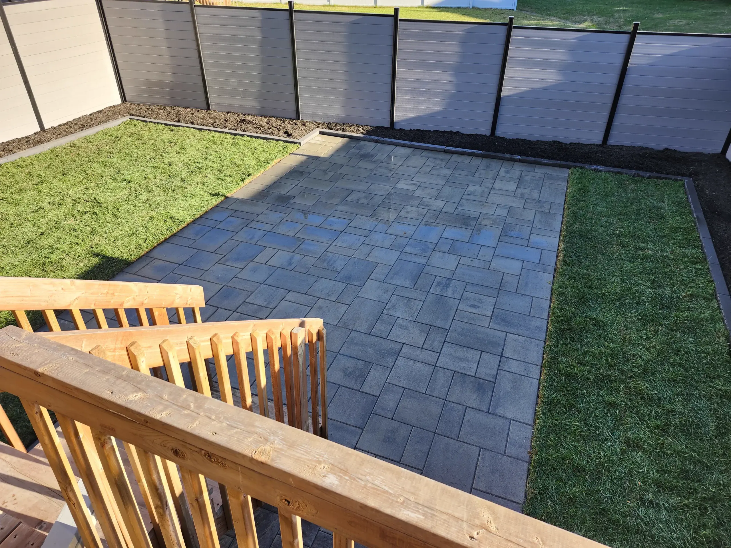 Grey backyard patio with side-yard transitions