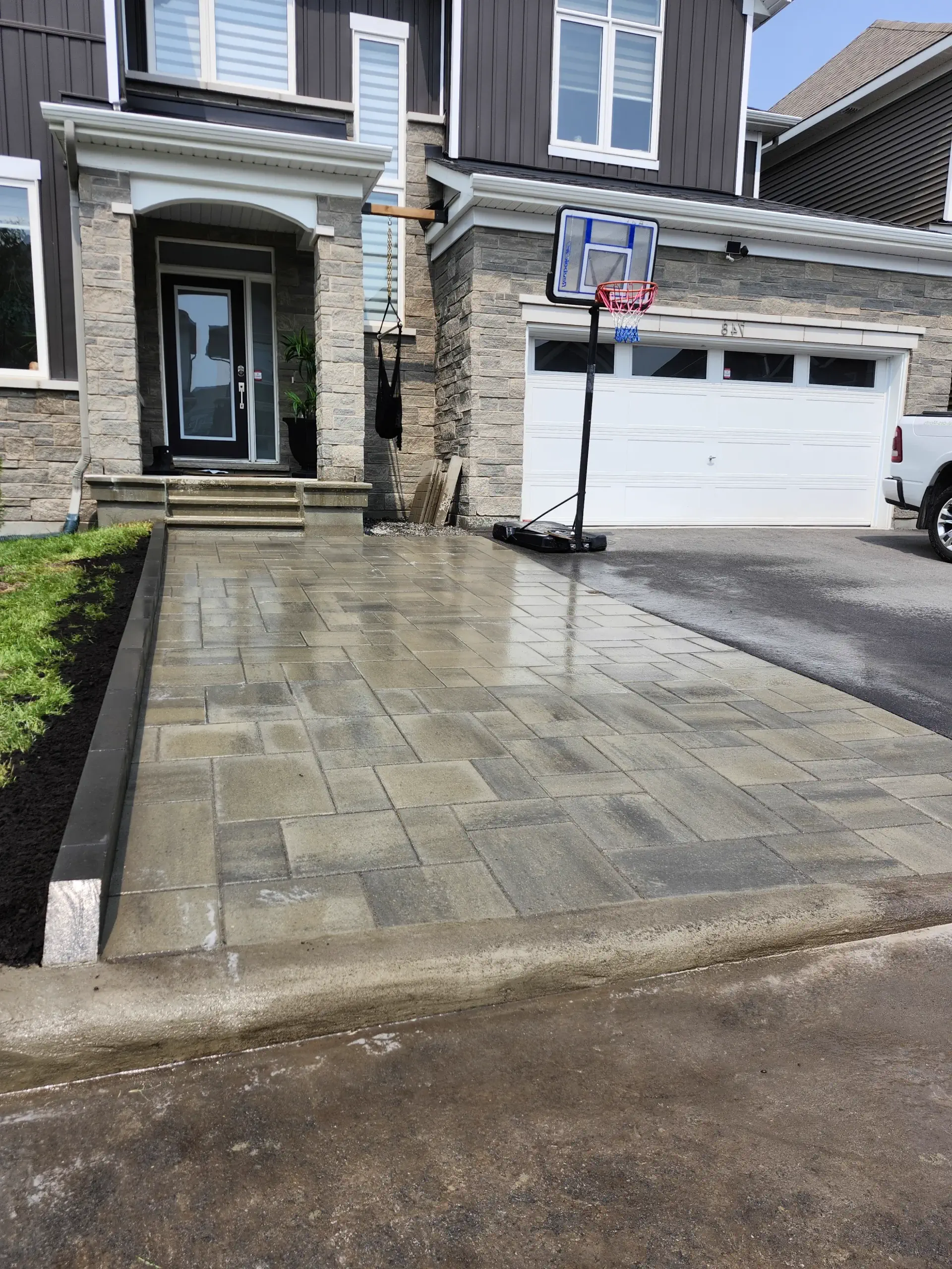 Grey paver driveway — urban + stone-veneer + modern siding angles