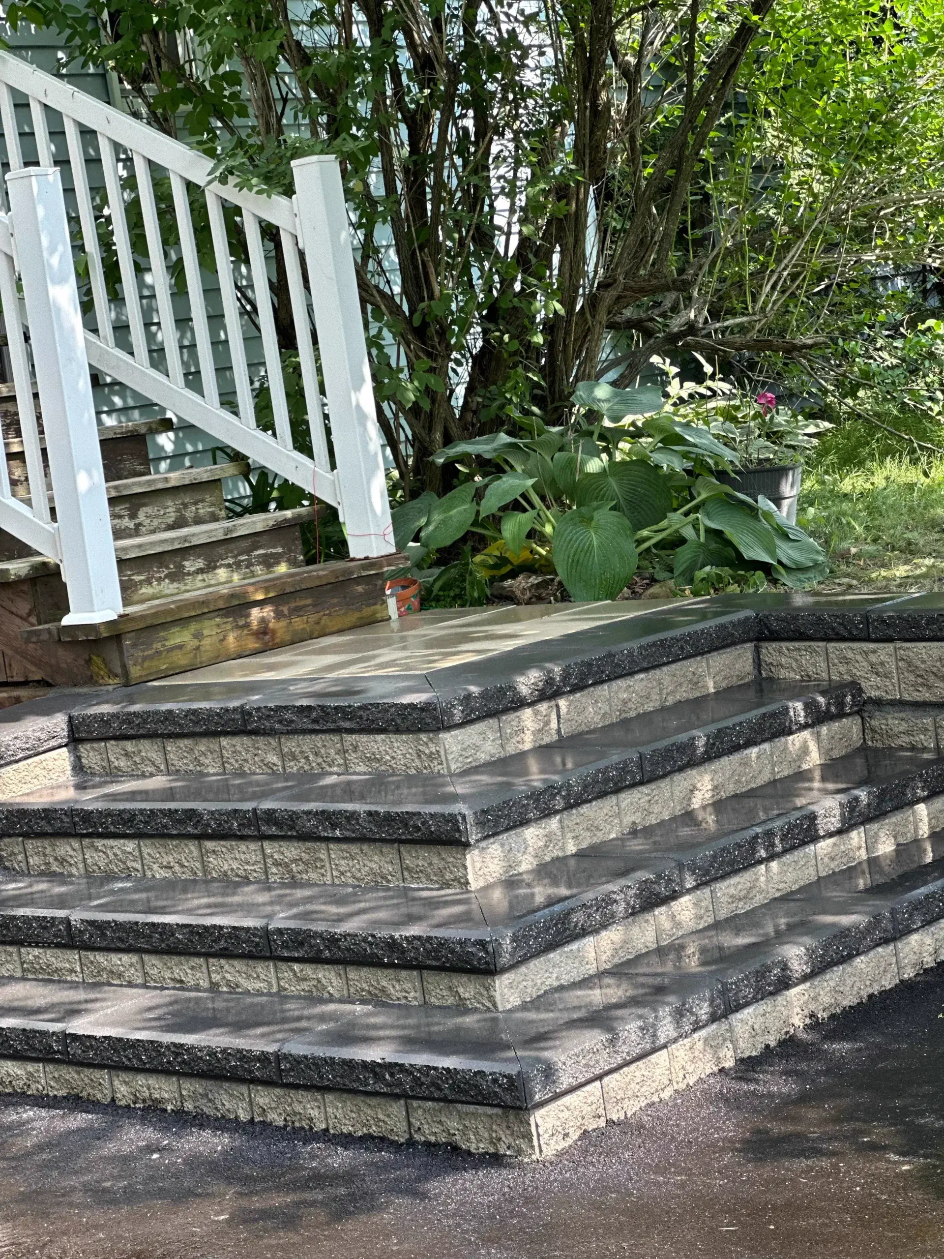 Block retaining wall with charcoal caps and step-pyramid landing